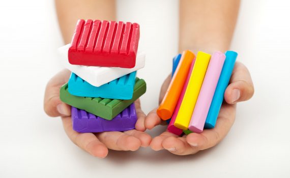 ילד מחזיק חתיכות פלסטלינה
