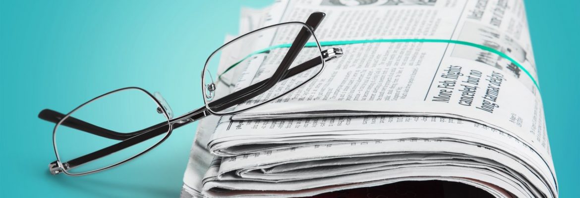 תמונה של משקפיים על עיתון מגולגל - להמחשת לחצן מאמרים