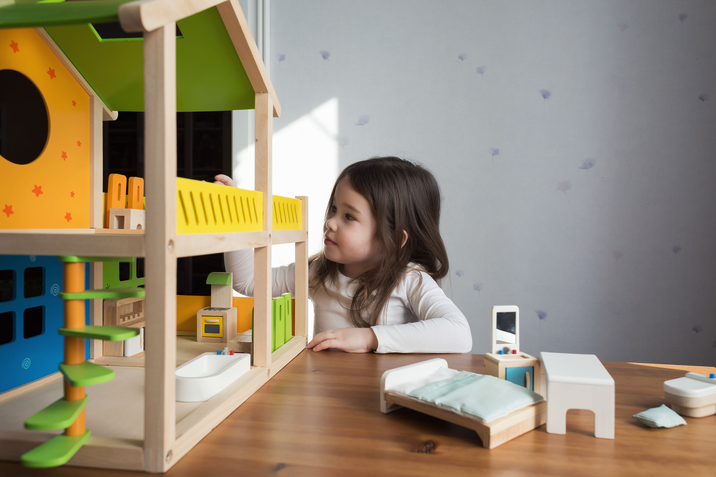 ילדה משחקת בבית בובות - להמחשת טיפול פסיכולוגי לילדים