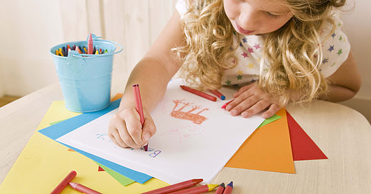 ילדה מציירת על דף