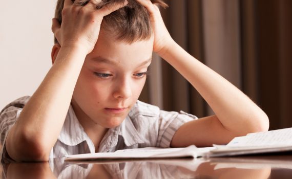 ילד עצוב מכין שיעורי בית